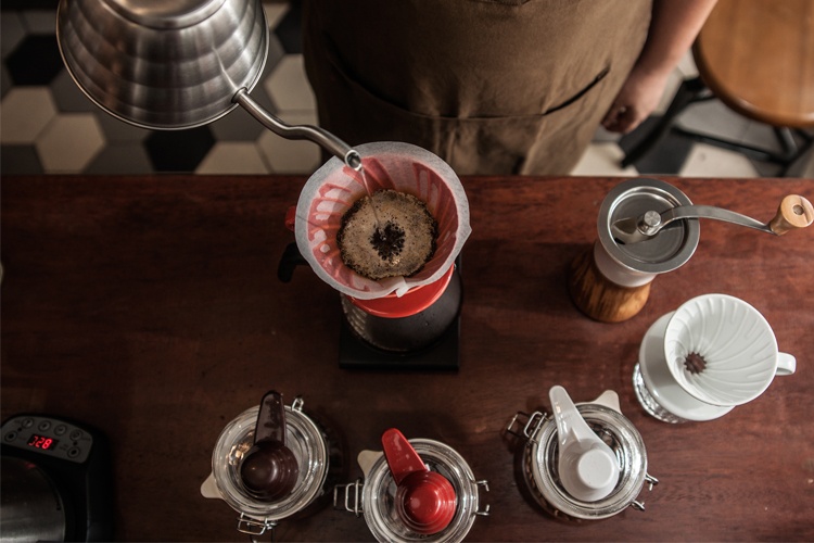 Barista menyeduh pada Hario V60 menggunakan Hario Buono